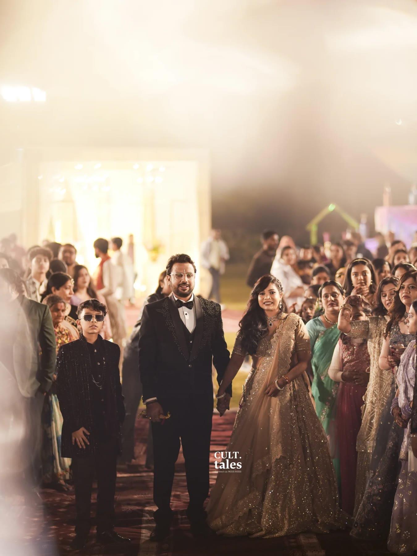 The bride and groom walking hand in hand among their guests