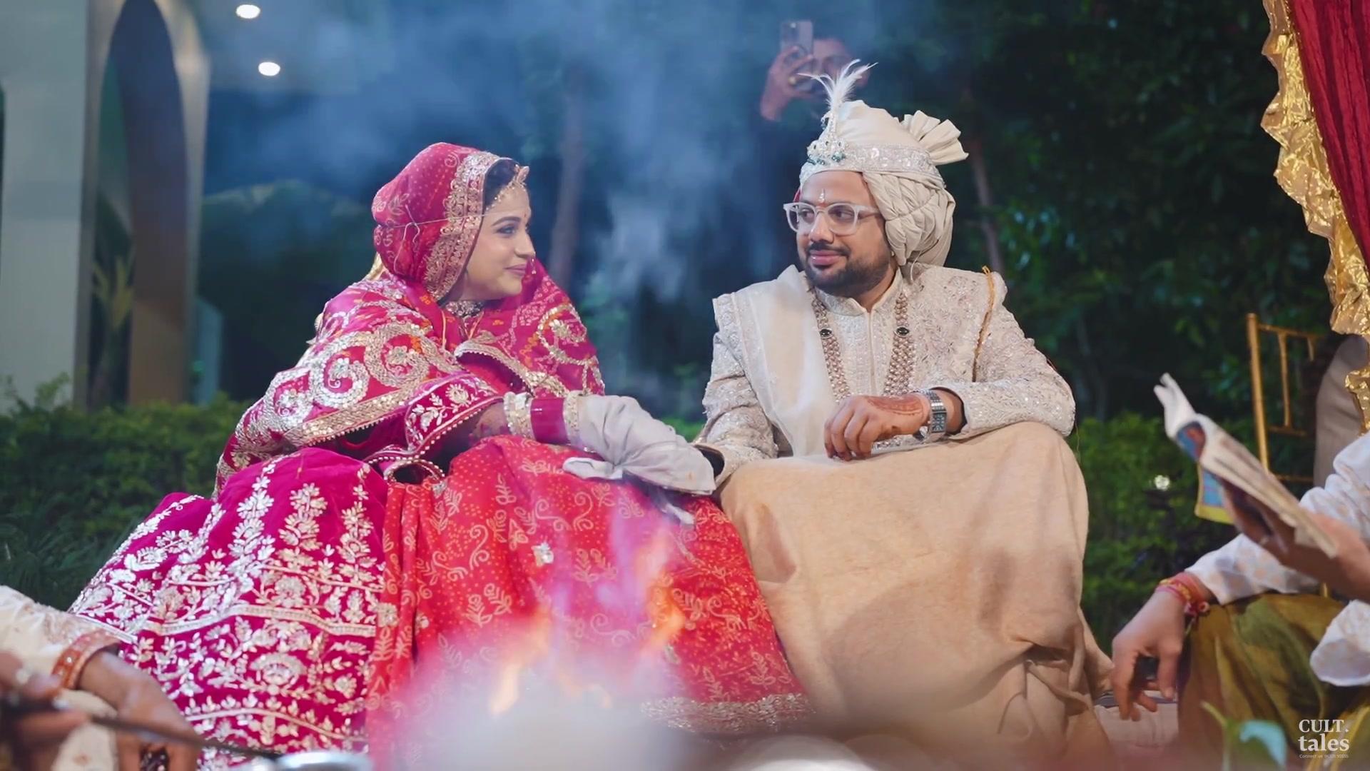 The couple smiling at each other beside the sacred fire